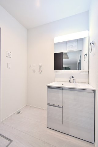 久喜市青葉５期全２棟　１号棟の独立洗面台|【洗面】三面鏡タイプの洗面台で身支度がしやすく、引出し収納も確保。洗濯機置場が近く家事動線にも配慮されています。可動棚やコンセント位置、脱衣スペースの広さは現地で確認ください。家族動線も。