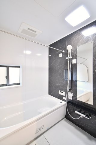 久喜市青葉５期全２棟　１号棟の浴室|【浴室】浴室は窓付きで換気しやすく、アクセントパネルで落ち着いた雰囲気。ミラーやカウンターの位置が使い勝手のポイントです。浴槽サイズ、またぎ高さ、清掃性は現地でご確認を。物干し位置も確認を。