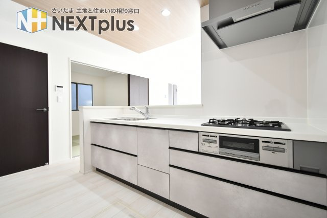 久喜市青葉５期全２棟　１号棟のキッチン|【キッチン設備】3口コンロ＋グリルで同時調理に対応。レンジフードも上部に配置され油煙対策にも配慮。天板素材や清掃性、火力、ガス種別、食洗機の有無など詳細はメーカー仕様でご確認ください。