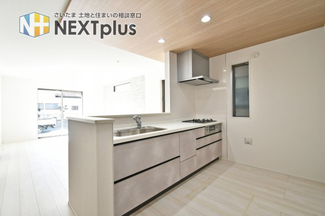 久喜市青葉５期全２棟　１号棟のキッチン|【キッチン】対面キッチンは会話しながら調理でき、配膳もスムーズ。作業台の広さと収納量がポイントです。冷蔵庫置場の幅、手元の視線、コンロ前の立ち位置など現地で確認を。家事動線も歩いて。