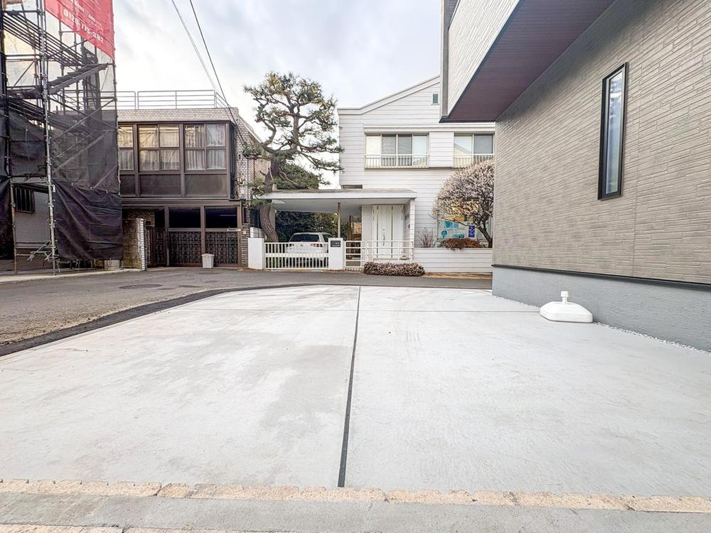 【Livele Garden.S】】国分寺新町の駐車場|広々とした駐車スペースは、お子様の遊び場としても活躍。白い外壁と緑豊かな木々が調和し、家族の毎日を彩る穏やかな住環境です。