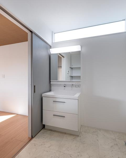 坂ノ市南１丁目ＮＷ　新築の独立洗面台|ゆったりとしたスペースの洗面台で日々の準備がスムーズに行えます。収納が充実しており整理整頓もしやすい仕様です。窓から自然光が入り明るい印象の洗面所です。