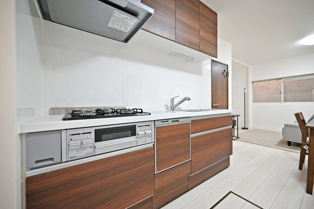 尼崎市稲葉荘4丁目中古戸建│4LDK+駐車1台可のキッチン|1階キッチンの内観写真です。食洗機が搭載されたシステムキッチン◎3口コンロでお料理の幅が広がります。 上下に収納があり収納豊富なため、常にすっきり保つことが出来ます