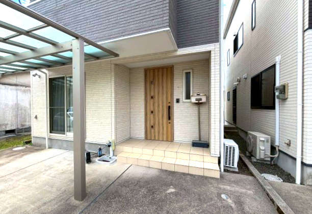 玉里団地2丁目　中古戸建ての玄関|カーポートがあるので雨天時などの車の乗り降りもラクラク。温かみのある玄関ドアです。