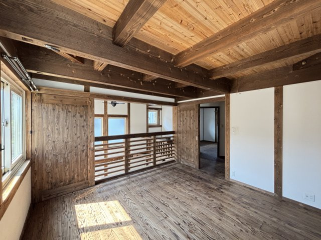中古戸建　　伴南５丁目の洋室|木の温もりが心地よい、明るい洋室です。無垢材の床と力強い梁が、洗練された和モダンな雰囲気を演出します。扉を開ければ吹き抜けと一体となり、より一層開放的な空間を楽しめます。
