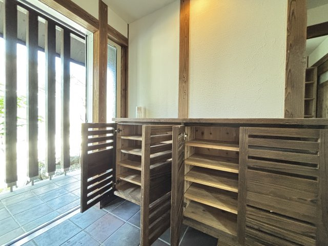 中古戸建　　伴南５丁目の玄関|格子のデザインが美しい、和モダンな雰囲気の下駄箱です。木の温かみが玄関全体に優しい印象を与え、訪れる人を温かく迎えてくれます。