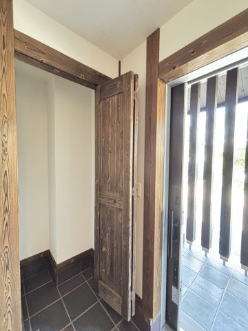 中古戸建　　伴南５丁目の収納|趣のある木目の扉が印象的なシューズインクローゼット。生活感を隠しながらも、木の温かみが玄関の雰囲気をより豊かにします。
