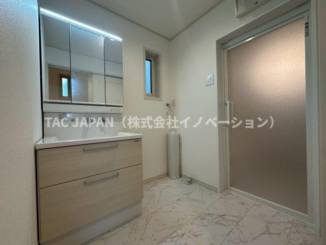 赤羽北3丁目Ⅱ期・全3棟の洗面所|大型の洗濯機を置いても余裕が感じられる脱衣スペースにはつなぎ目がなくお手入れが楽なシームレスタイプのお洒落な洗面ユニットを完備。