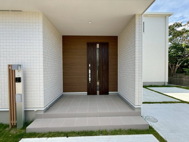 グラファーレ南城市玉城糸数 3期・1号棟の玄関|屋根付きで置き配スペースも確保できる玄関ポーチ／TVモニター付きインターフォン