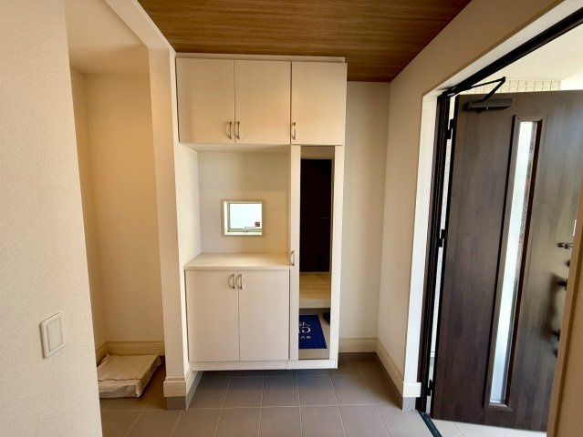 グラファーレ南城市玉城糸数 3期・1号棟の玄関|全身鏡付き天井高シューズクローゼットの後ろにはシューズクローク◎