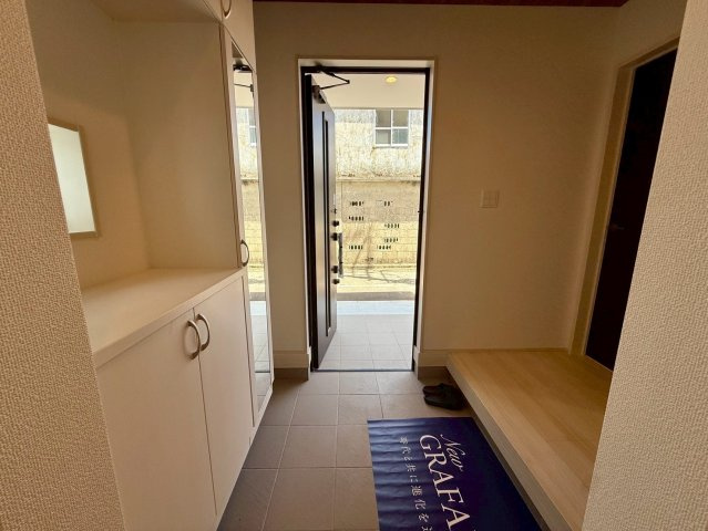 グラファーレ南城市玉城糸数 3期・1号棟の玄関|ベビーカーや自転車もそのまま収納できる広々玄関からシューズクロークへ／玄関収納付き