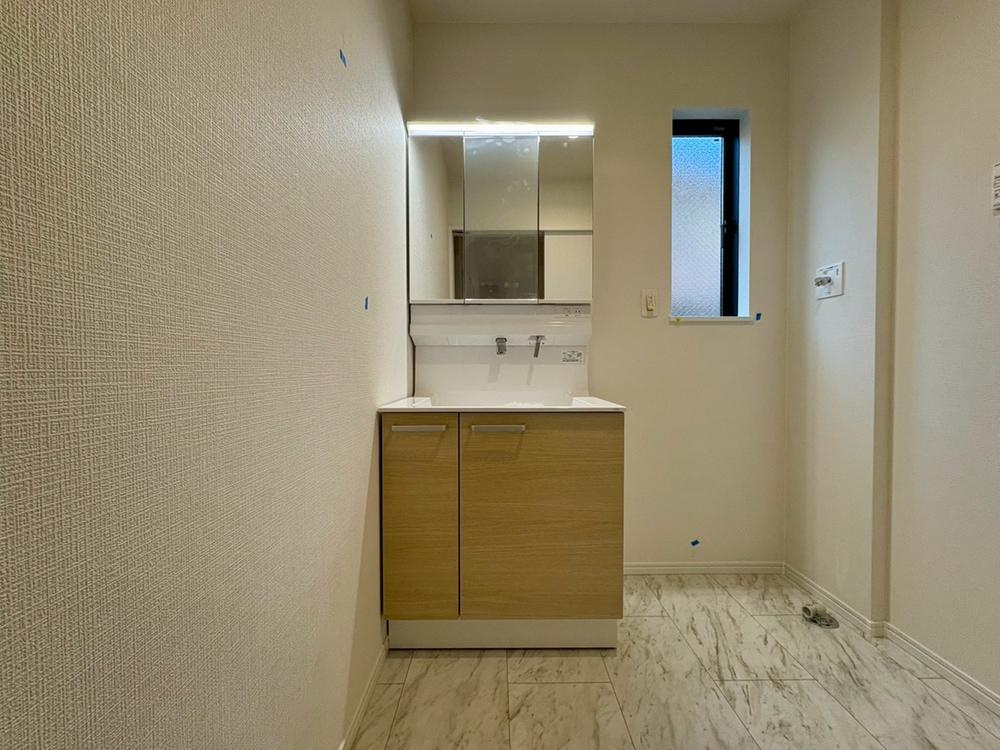 【Heartfull Town】東大和南街７期の洗面所|三面鏡付きの洗面化粧台は、左右の鏡を開けば横顔や後頭部までしっかりチェック可能。朝の身支度もスムーズにこなせる、機能的で快適な洗面空間です。