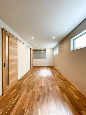 本山中町１丁目新築戸建の居間・リビング|リビングのフローリングは無垢材で、輻射熱と無垢材の床は相性が良く、木の自然で優しい暖かさが部屋全体に広がります。階段には引戸を設置して断熱性の高い空間を実現。