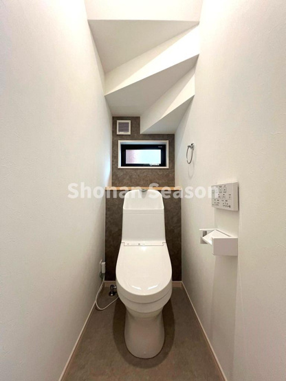 【トイレ】 | 階段下のデッドスペースを有効活用したトイレ。
コンパクトながらも小窓から光が入る、明るく落ち着いた空間◎