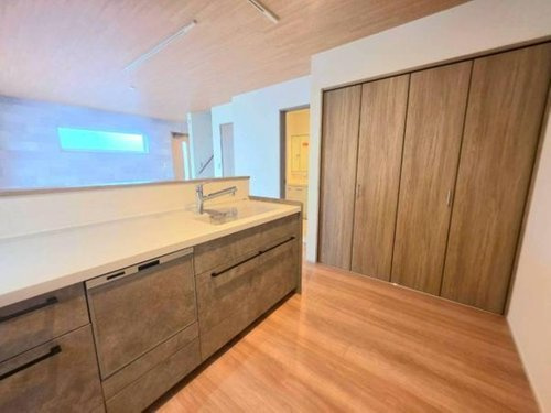 小川町１丁目新築住宅の居間・リビング|キッチンのすぐそばに収納があり使い勝手に配慮されています。収納力を備えたクローゼットが設置されていて日常生活に便利な設計です。