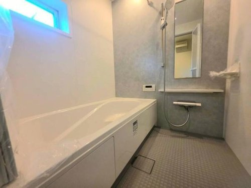 小川町１丁目新築住宅の浴室|清潔感のあるバスルームです。浴槽と洗い場が広く設計されています。窓付きで換気しやすい環境です。壁面収納や鏡も付いています。ゆったりとした空間が広がっています。