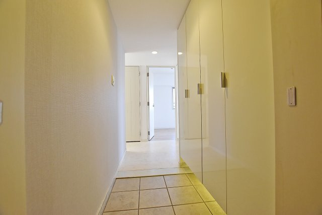 ネバーランド江坂垂水町の玄関|玄関には天井まで続く大きな収納スペース有。