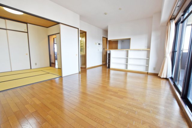 デュアル江坂広芝町の居間・リビング|リビング横には和室あり。家事の途中でお昼寝なんかもできますね。