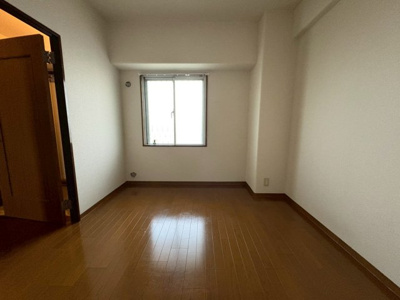 【洋室】 | パレス南塚口1号棟 | 明るい木目調のフローリングの洋室。大きな窓があり、たっぷりの光を取り込めます。