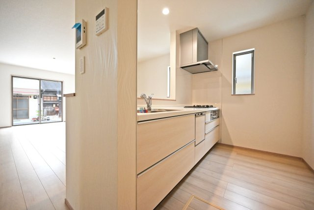 ハートフルタウン浜町新築一戸建て│2SLDK・3LDK+駐車1台可のキッチン|1階キッチンユニット越しに撮影した内観写真です。 キッチンに小窓が設けており、調理で煙だらけになってもすぐに換気できます。