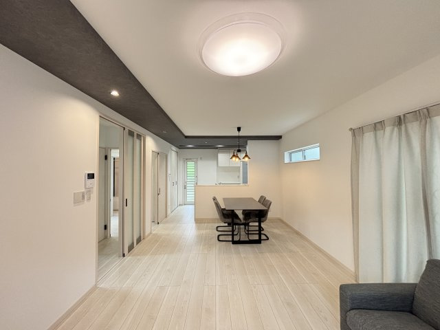 中古戸建　相田4丁目の居間・リビング|キッチンから洗面・浴室へ回遊できる家事ラク動線。同時進行の家事に便利な間取りです。