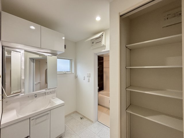 中古戸建　相田4丁目の独立洗面台|タオルや着替えをまとめて収納できるクローゼット付き。
