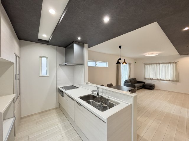 中古戸建　相田4丁目のキッチン|白を基調とした、清潔感あふれるシステムキッチンとカップボード。空間に統一感が生まれ、洗練された印象を与えます。