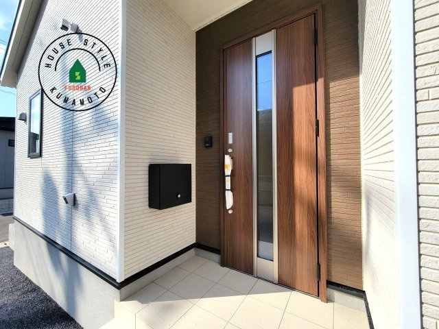 合志市栄第5-2棟(1号棟)の玄関|地盤調査済 / 玄関へ向かうまでのアプローチに漂う上質が期待感をもたせます。玄関は建物の顔。落着きを醸し出した自己主張が心に訴えてきます。