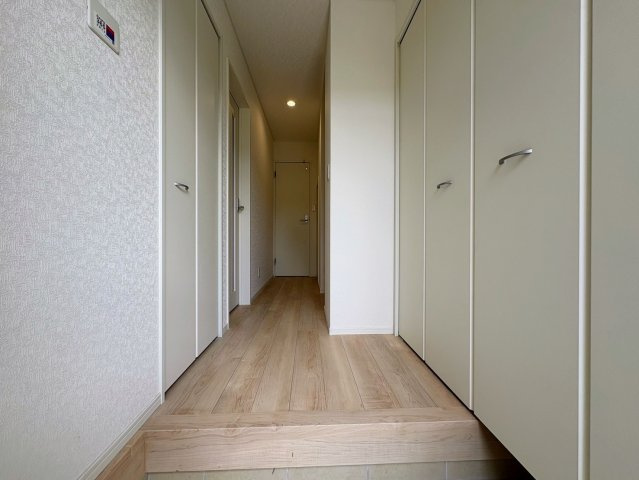 クレイドルガーデン南城市大里稲嶺 第4・１号棟の玄関|玄関の上り框からリビング＆階段へ続く廊下