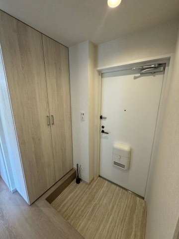 エトワール日野台の玄関|落ち着いた木目調のシューズボックスを備えた玄関。空間にゆとりがあり、出入りや荷物の持ち運びもスムーズに行えます。