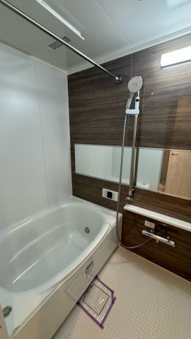 エトワール日野台の浴室|ダークブラウンのアクセントパネルが印象的なバスルーム。横長ミラーとワイド浴槽で、見た目も機能も快適に。落ち着いた空間で、一日の疲れをゆったり癒やせます。