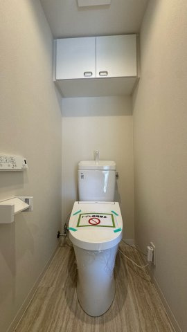 エトワール日野台のトイレ|シンプルで清潔感のあるトイレスペース。上部には吊戸棚があり、トイレットペーパーや掃除用品などの収納にも便利です。