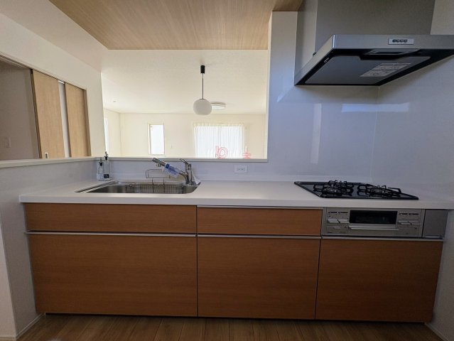 グラファーレ南城市玉城糸数 3期・２号棟のキッチン|レンジフード＆ガスコンロ＆流し台／キッチンからダイニングの眺め