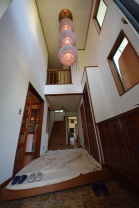 【玄関】 | 伊東市岡　戸建 | 広い玄関には天井高い吹き抜けがあり豪華なシャンデリアがあります。