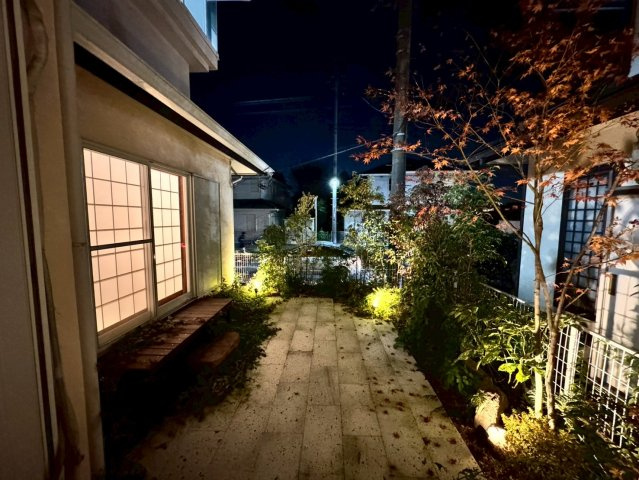 狭山市柏原中古戸建の庭|柔らかなライトが植栽を照らし夜は庭全体が幻想的な雰囲気に。帰宅時にほっと和める明るさと、季節の彩りを美しく引き立てる上質な夜景が魅力です、