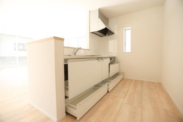 光吉第3-2号棟の独立洗面台|清潔感のある洗面台と明るい洗面所の空間です。大きな鏡と収納スペースを備えています。隣接するバスルームへの動線がスムーズです。床材の色合いも落ち着いています。水まわりが機能的にまとまっています。