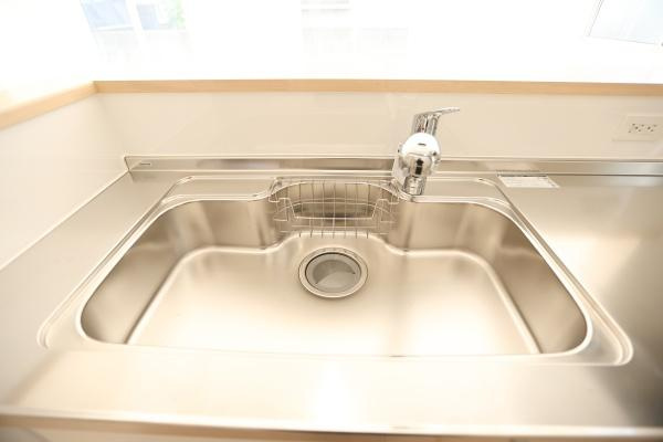 光吉第3-2号棟のトイレ|シンプルなデザインの空間で清潔感があります。壁付けのペーパーホルダーが設置されています。床にはナチュラルな色合いのフローリングを使用しています。手洗い器付タンクが備わっています。