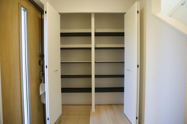 光吉第3-2号棟の玄関|明るい色合いのフローリングが空間全体をすっきりと見せてくれます。白を基調とした壁が玄関をより広く感じさせます。段差部分も丁寧に仕上げられており使い勝手に配慮されています。