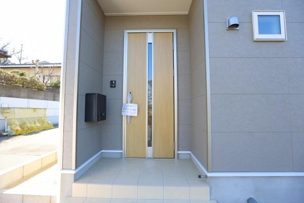 光吉第3-2号棟の玄関|玄関には大容量の収納スペースが備わっています。シンプルな棚設計で片付けがしやすい仕様です。ドア付きで見た目もすっきりとしています。床の切り替え部分も印象的です。明るい色合いの玄関が魅力です。