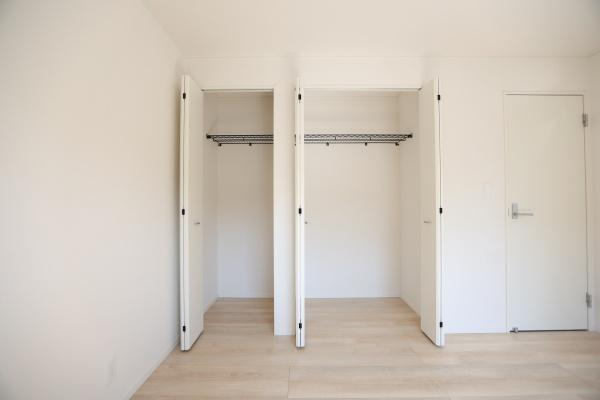 光吉第3-2号棟の独立洗面台|収納スペースを備えた洗面化粧台が設置されています。鏡の裏にも収納できる設計です。明るい空間で日々の身支度がしやすい洗面所です。床材とのコントラストがアクセントになっています。