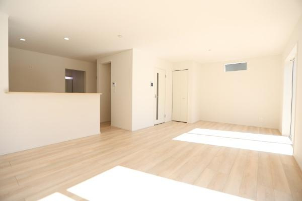 光吉第3-2号棟の居間・リビング|リビングは大きな窓から光が差し込み明るい空間が広がっています。シンプルな内装で家具の配置もしやすいです。床材の色合いがやわらかく室内の雰囲気と調和しています。