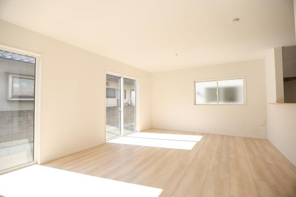 光吉第3-2号棟の居間・リビング|リビングは白を基調とした空間になっており明るさが印象的です。窓から自然光が差し込む室内は開放感を感じられます。ダイニングテーブルも設置されておりすっきりとした印象です。