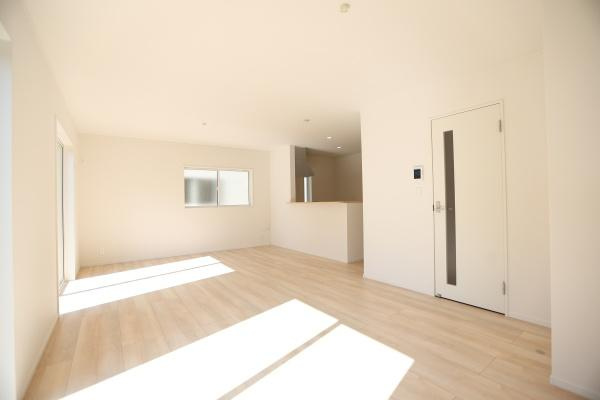 光吉第3-2号棟の居間・リビング|リビングには大きな窓があり室内が明るく感じられます。床には落ち着いた色合いのフローリングが使われています。シンプルな内装が空間の広さを強調しています。収納スペースも備えられ使い勝手に配慮されています。