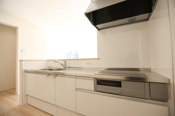 光吉第3-2号棟のキッチン|シンプルで洗練された印象のキッチンです。明るいフローリングが空間をより広く感じさせます。窓からの採光があり清潔感を感じやすいレイアウトです。収納スペースも豊富に確保されています。