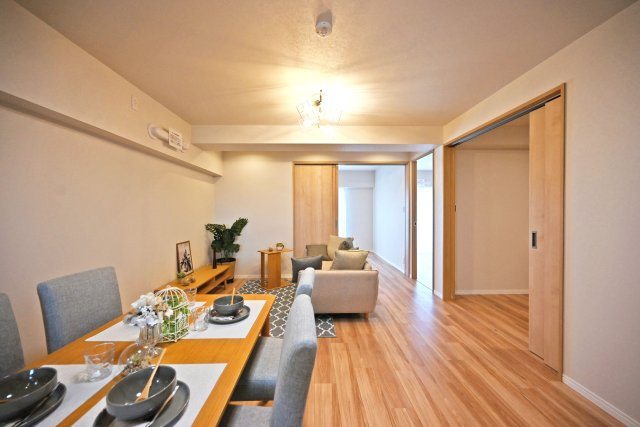 メガロコープ西宮Ⅱ1号棟の居間・リビング|キッチン側からリビング側に向かって撮影した内観写真です。奥行きがある縦長リビングなので、収納や家具の配置、インテリアコーディネートがしやすいです。