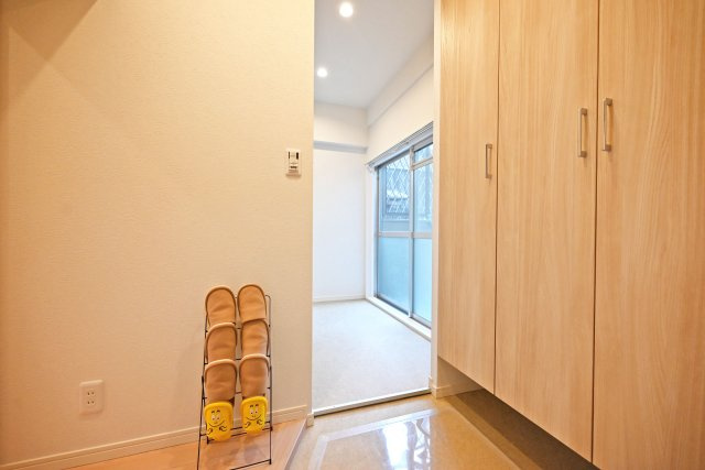 メガロコープ西宮Ⅱ2号棟の玄関|玄関入ってすぐの内観写真です。 右側に上部まで収納があるシューズボックスが配置されています。奥側にはシューズインクローク付です。