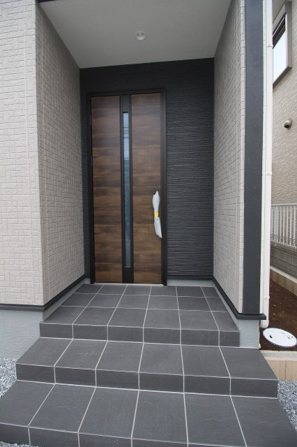 野木南赤塚　第1の玄関|重厚感ある木目調の玄関ドアが印象的。屋根付きポーチで、雨の日も落ち着いて出入りできます。