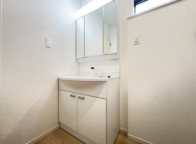 【独立洗面台】 | 新座市畑中2丁目　新築一戸建住宅　全9棟　(志木本店) | 鏡の裏に小物を収納できる三面鏡洗面化粧台。
三面鏡は多角的にチェックできるのでヘアアレンジやメイクもスムーズに行えます。