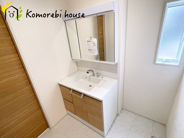 上尾市原市北1丁目　新築一戸建て　ブルーミングガーデン　01の独立洗面台|三面鏡の裏にたっぷりと収納スペースを確保した機能的な洗面台。身支度のしやすさと実用性を兼ね備え、朝の忙しい時間をさりげなくサポートします。															
