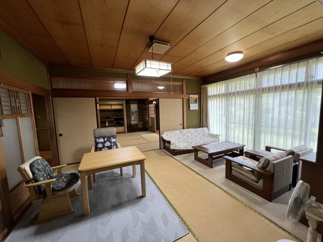 津山市押入中古住宅 5DK＋ガレージの居間・リビング|窓の前に絨毯を配した、応接間としても使えるゆとりの和室